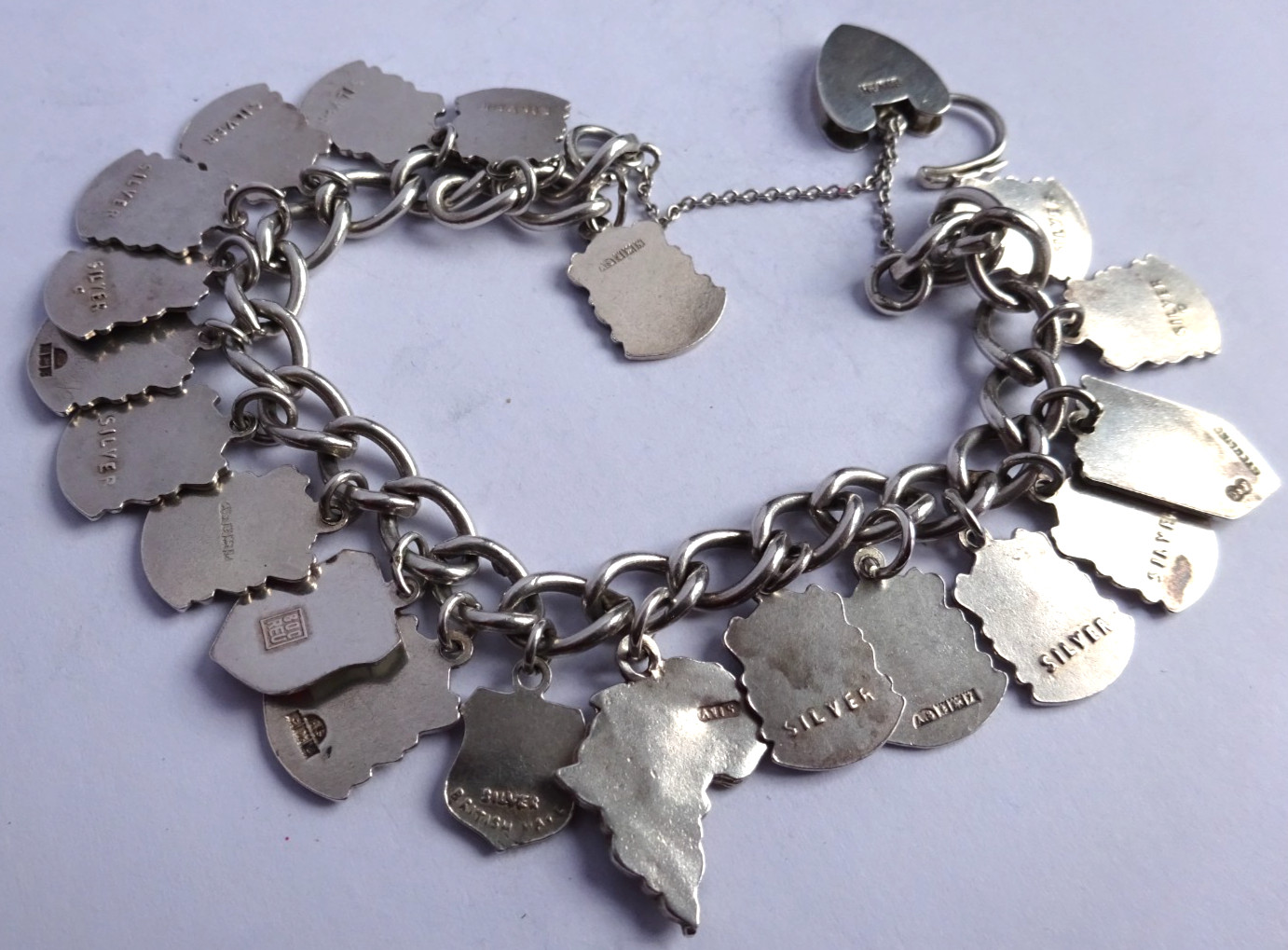 Vintage solid silver charm bracelet & numerous silver & enamel travel shields