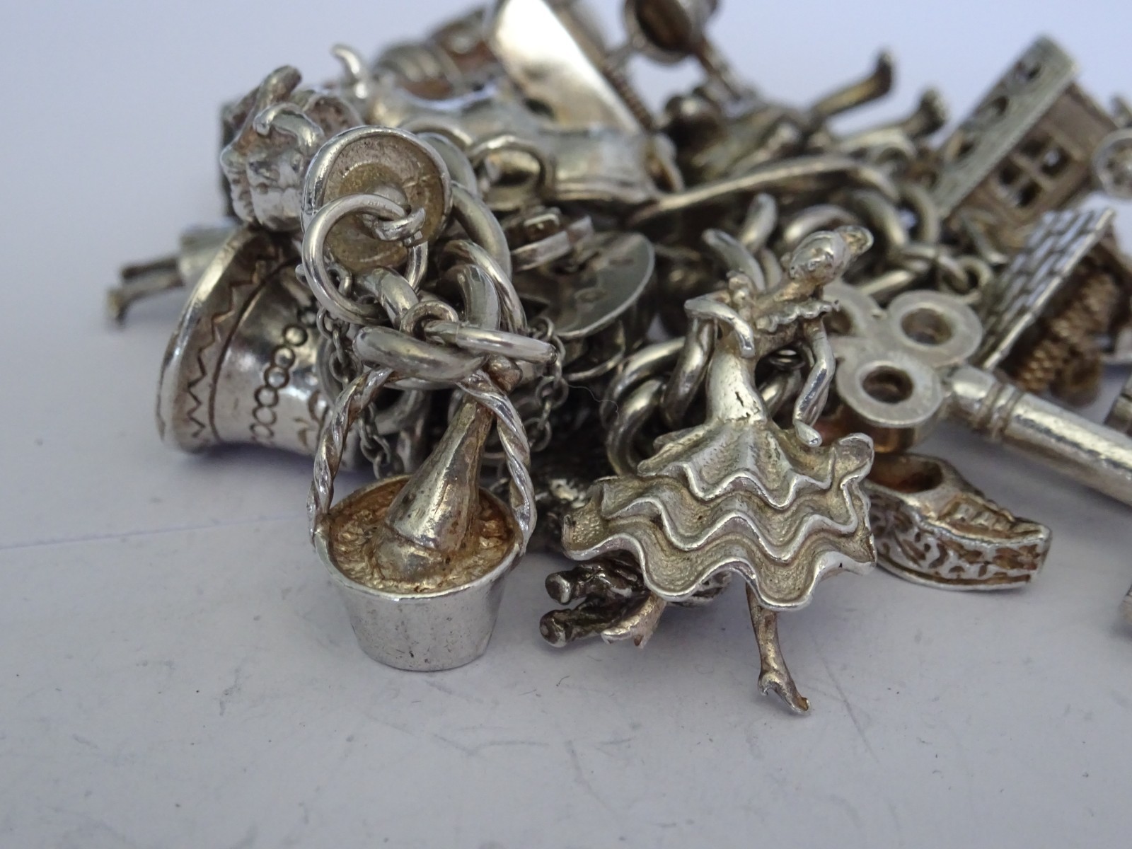 Vintage heavy solid silver charm bracelet &many curious silver charms inc moving