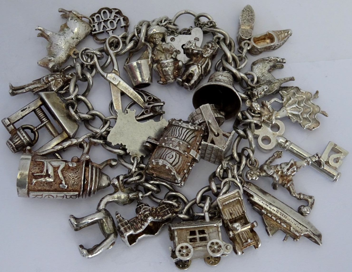 Vintage heavy solid silver charm bracelet &many curious silver charms inc moving