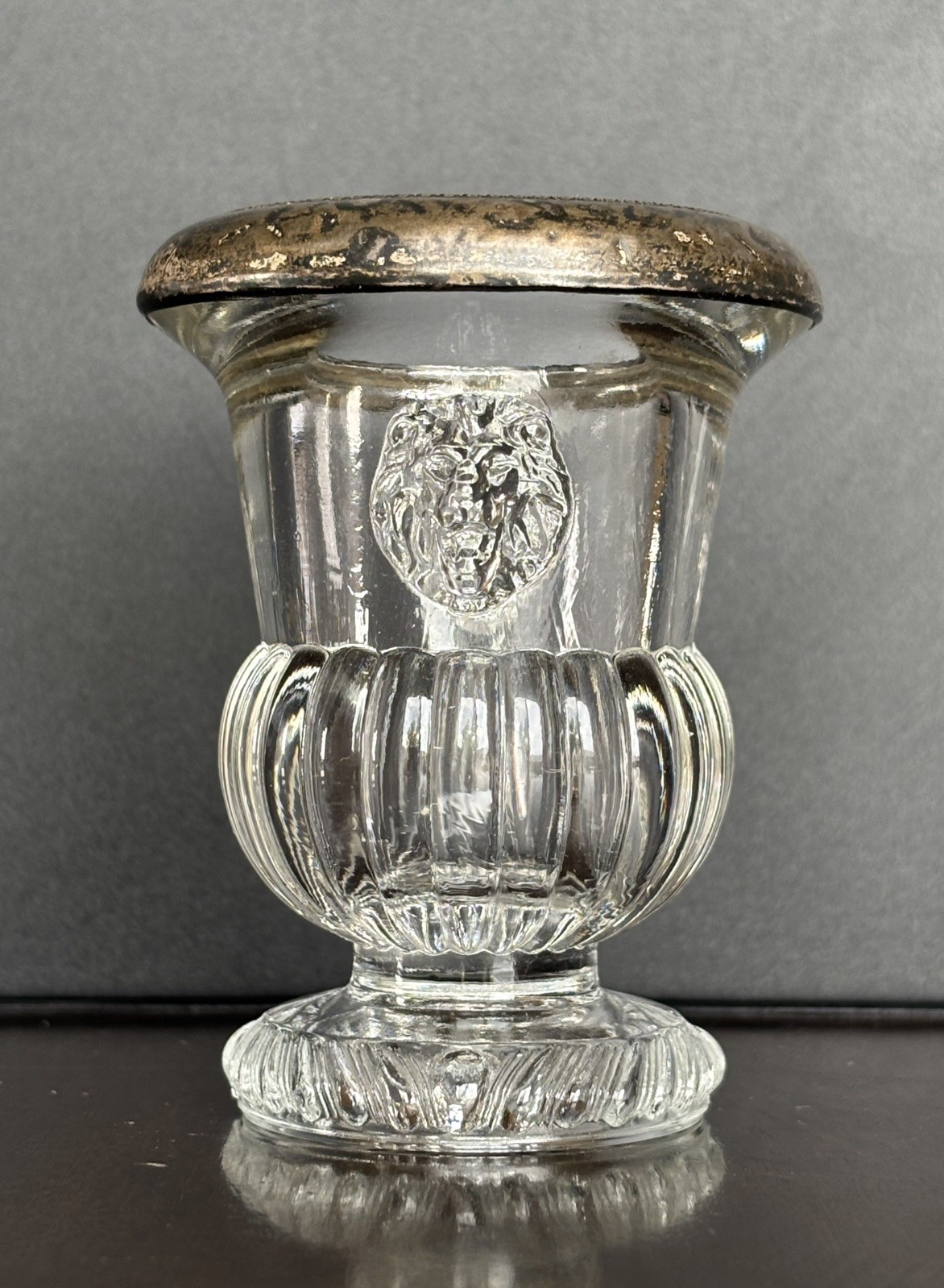 F.B Roger pressed glass toothpick holder with a silver rim and molded lion heads