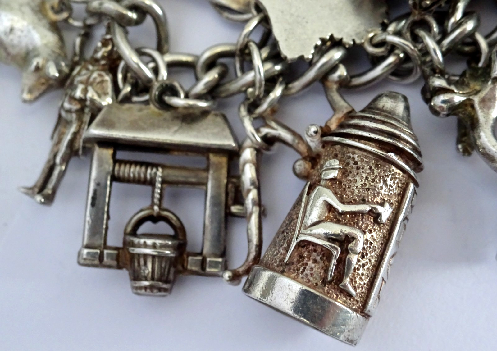 Vintage heavy solid silver charm bracelet &many curious silver charms inc moving