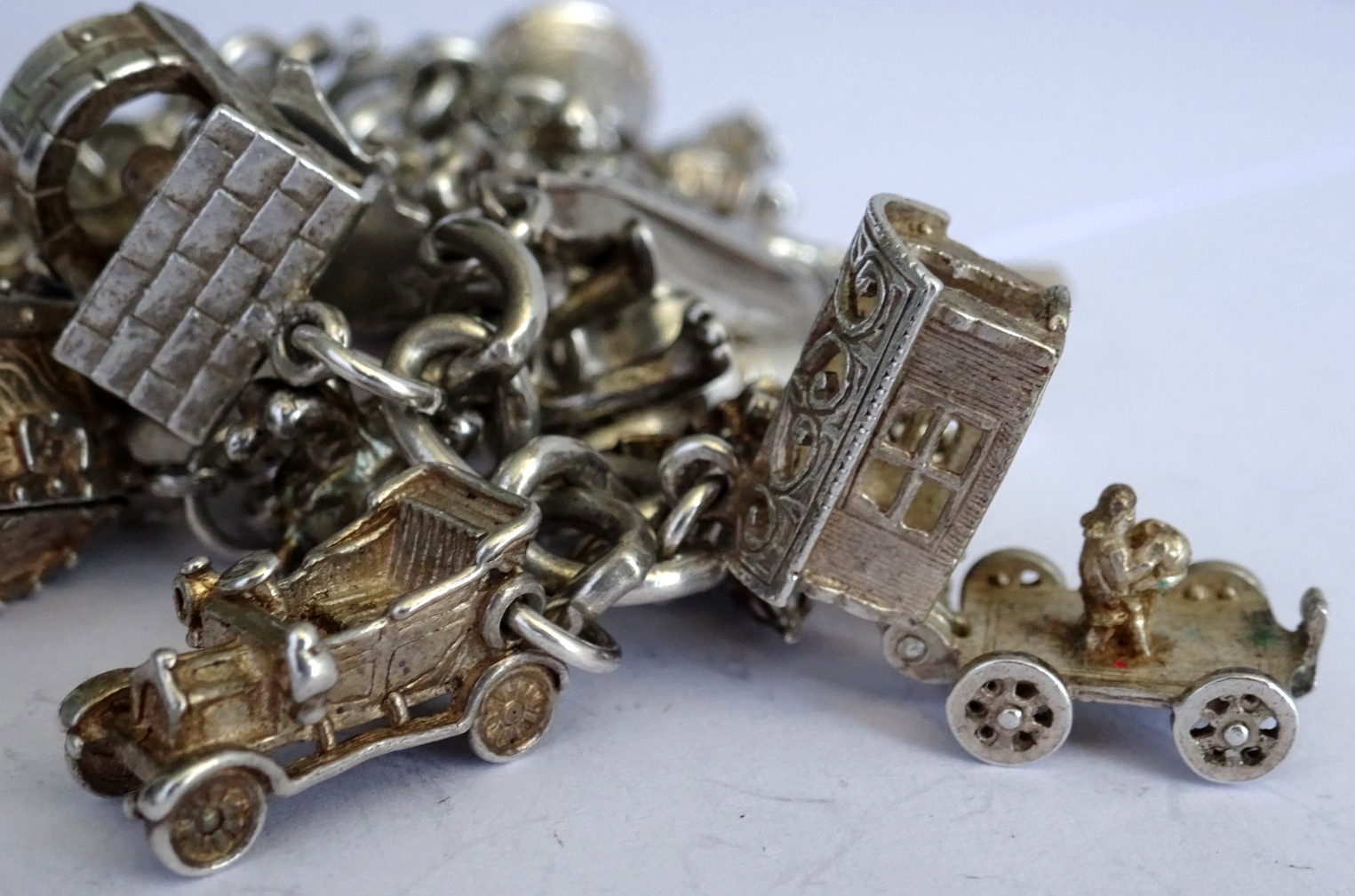 Vintage heavy solid silver charm bracelet &many curious silver charms inc moving