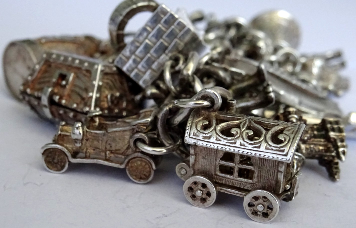 Vintage heavy solid silver charm bracelet &many curious silver charms inc moving