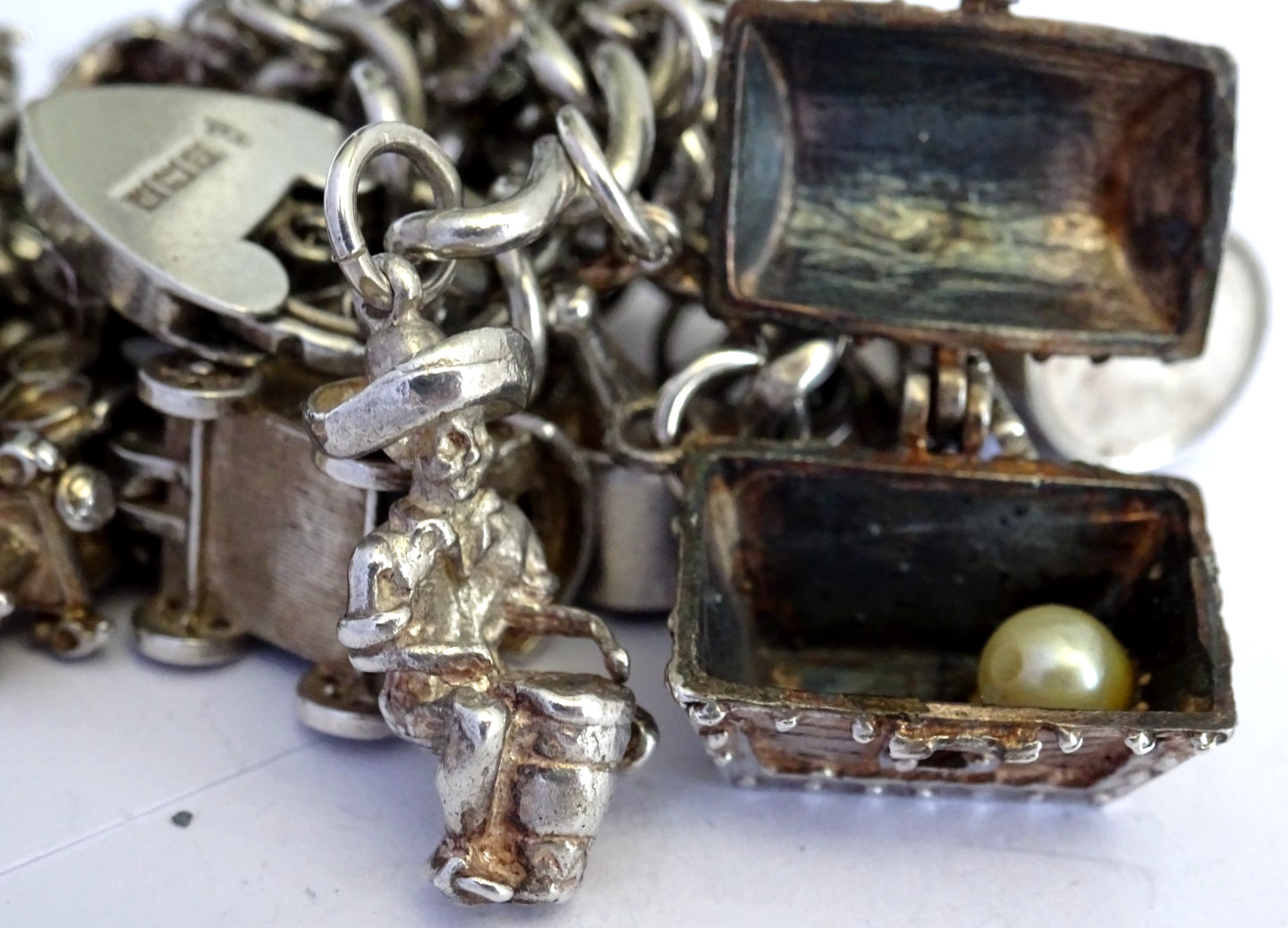 Vintage heavy solid silver charm bracelet &many curious silver charms inc moving