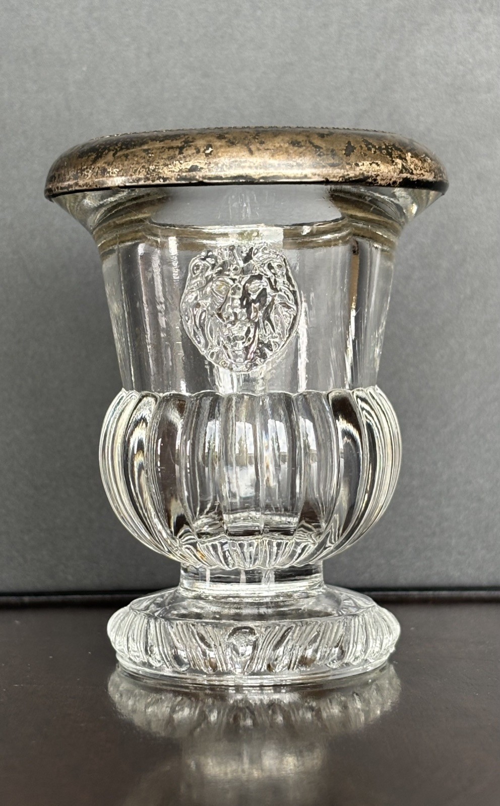 F.B Roger pressed glass toothpick holder with a silver rim and molded lion heads