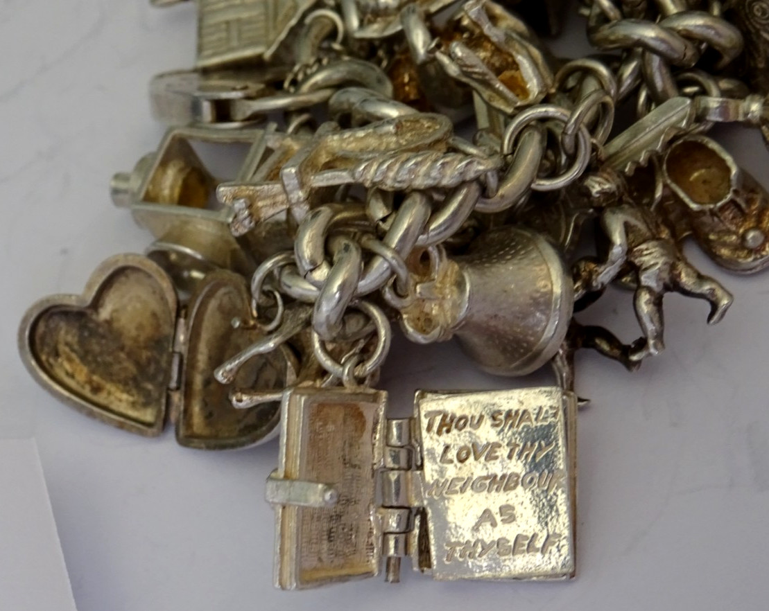 Vintage 102.5g solid silver charm bracelet,many curious silver charms inc moving