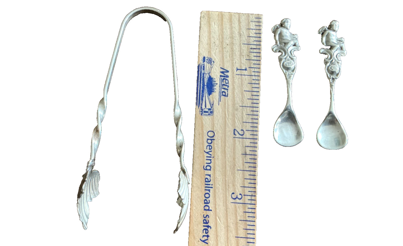 3 ITEMS :TWO SILVER CHERUB SALT SPOONS & ONE .925 TONGS LEAF ENDS 17.8 gm total