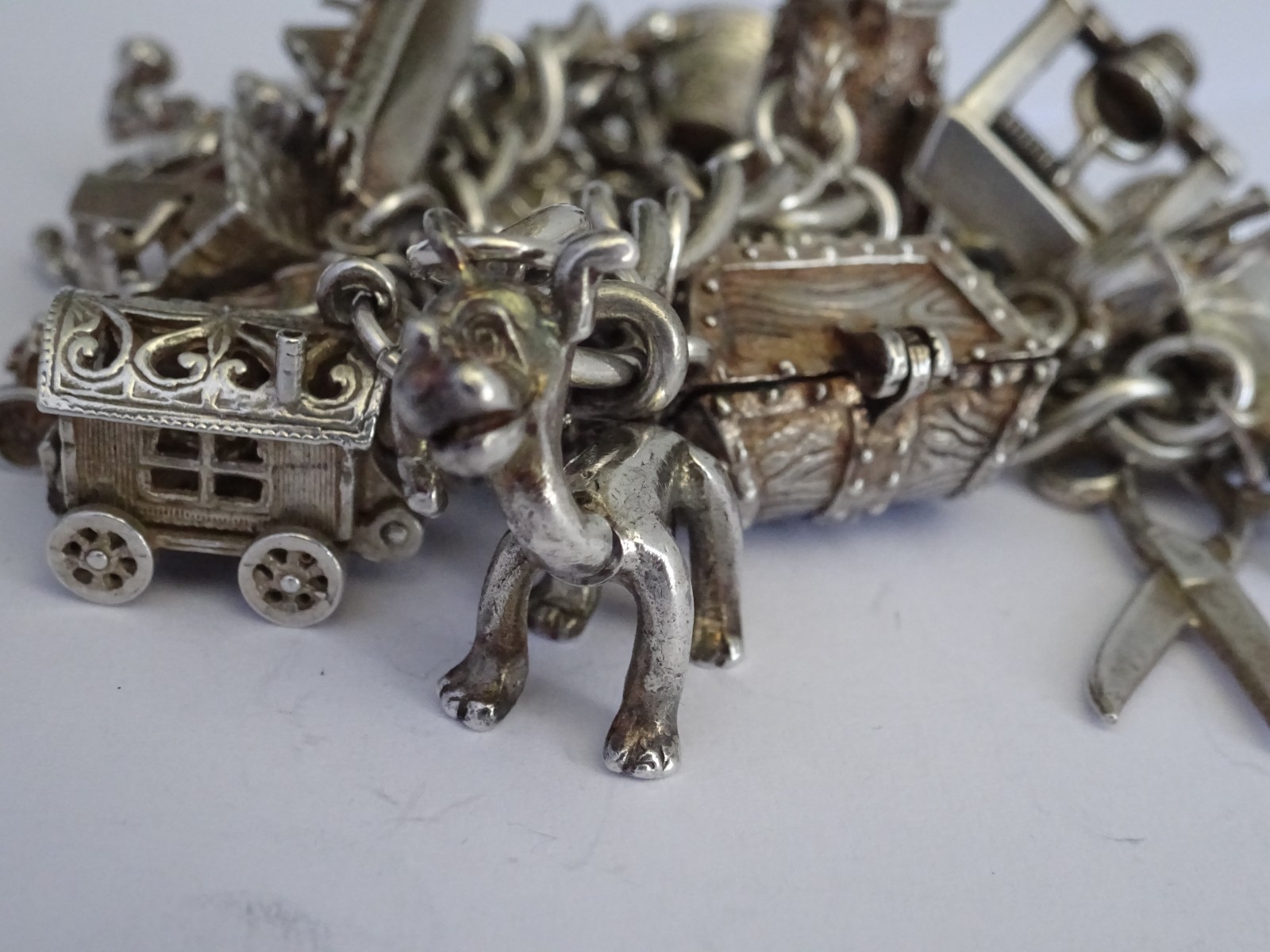 Vintage heavy solid silver charm bracelet &many curious silver charms inc moving