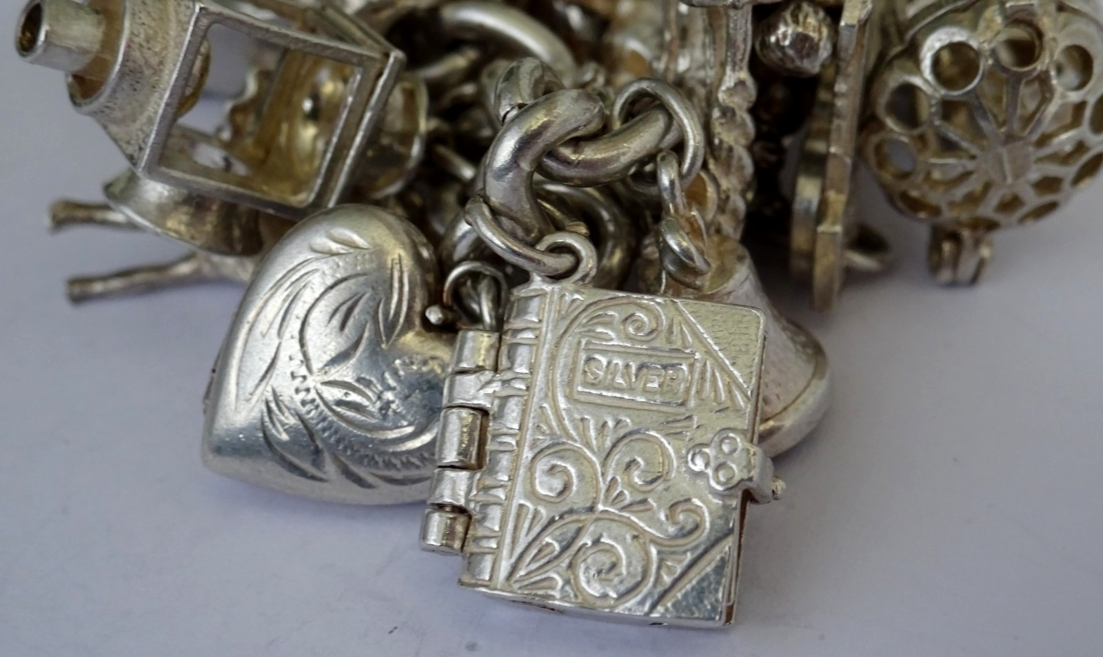 Vintage 102.5g solid silver charm bracelet,many curious silver charms inc moving