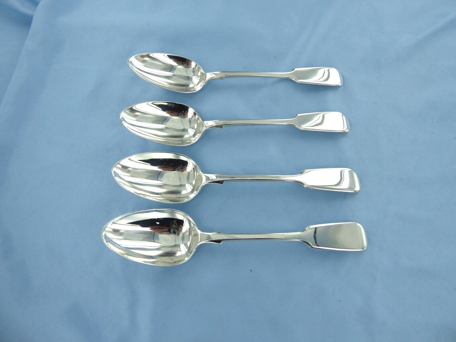 AN ANTIQUE SET OF FOUR STERLING SILVER FIDDLE BACK DESSERT SPOONS, LONDON 1857.