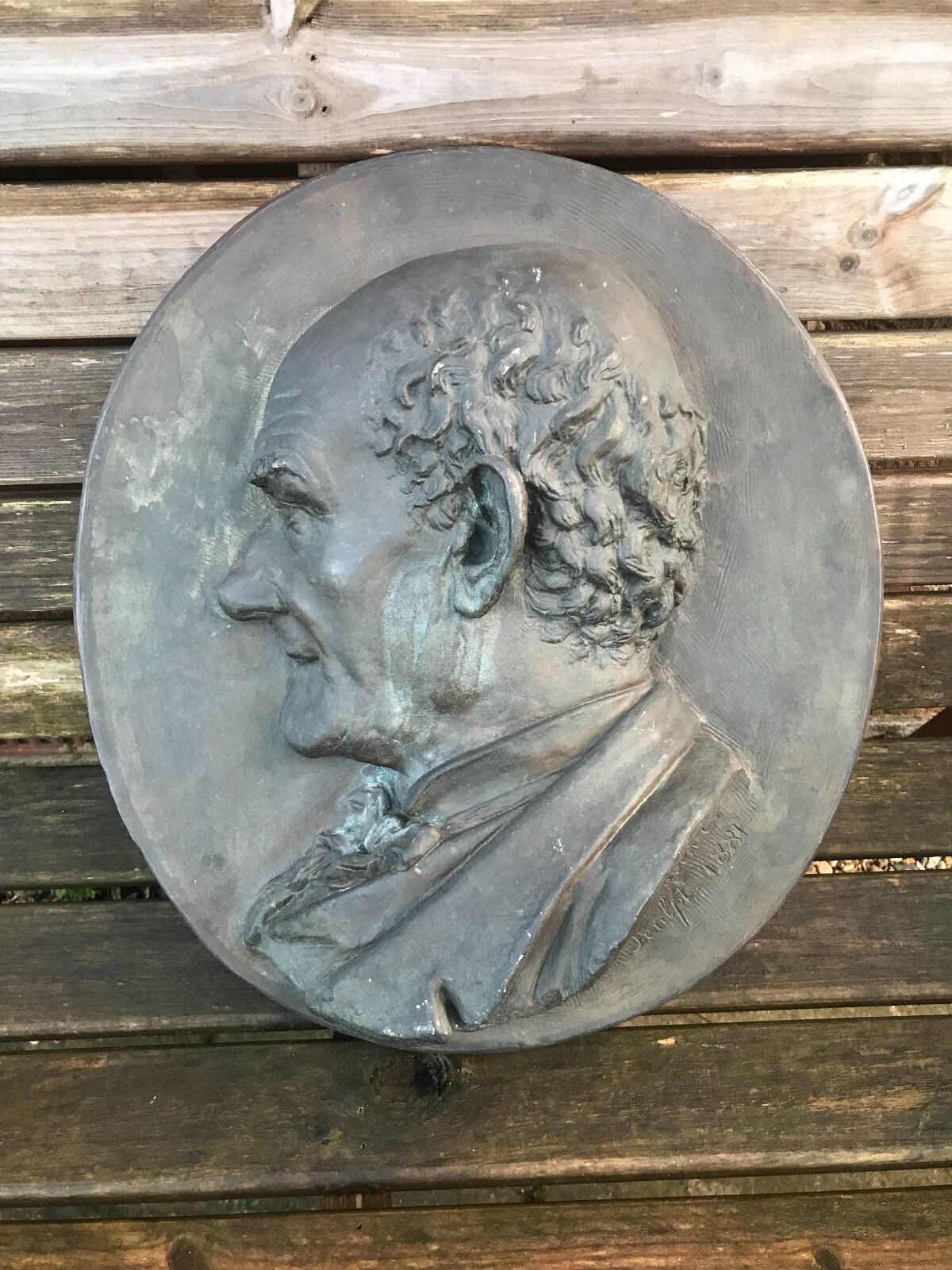 A bronze portrait plaque depicting a victorian gentleman 1881 signed.