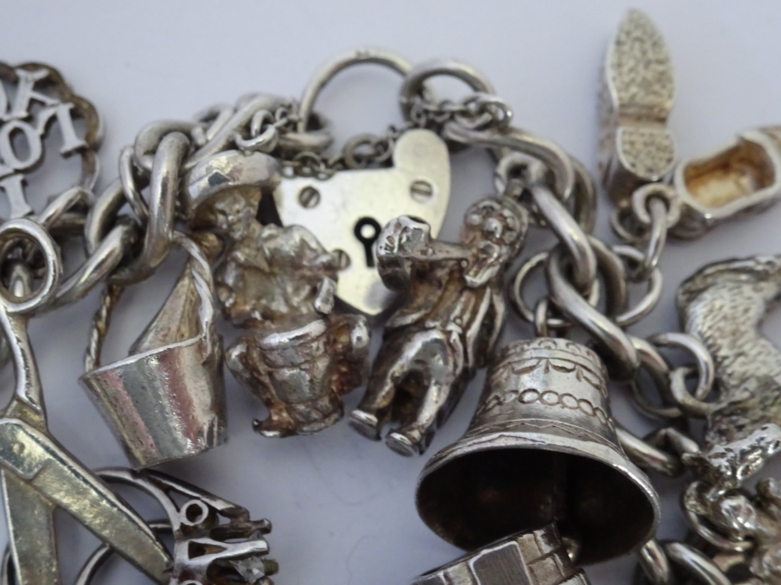 Vintage heavy solid silver charm bracelet &many curious silver charms inc moving