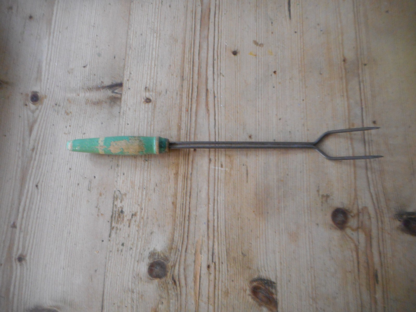 Old 50s green and cream toasting fork, 12″ long, some colour loss. Fireplace.