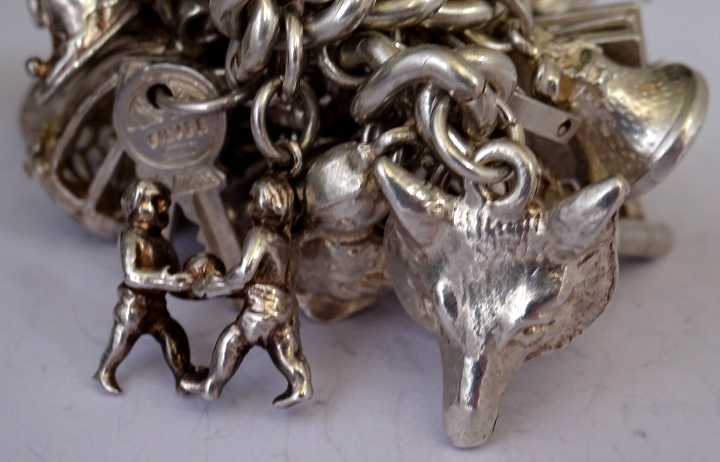 Vintage 102.5g solid silver charm bracelet,many curious silver charms inc moving