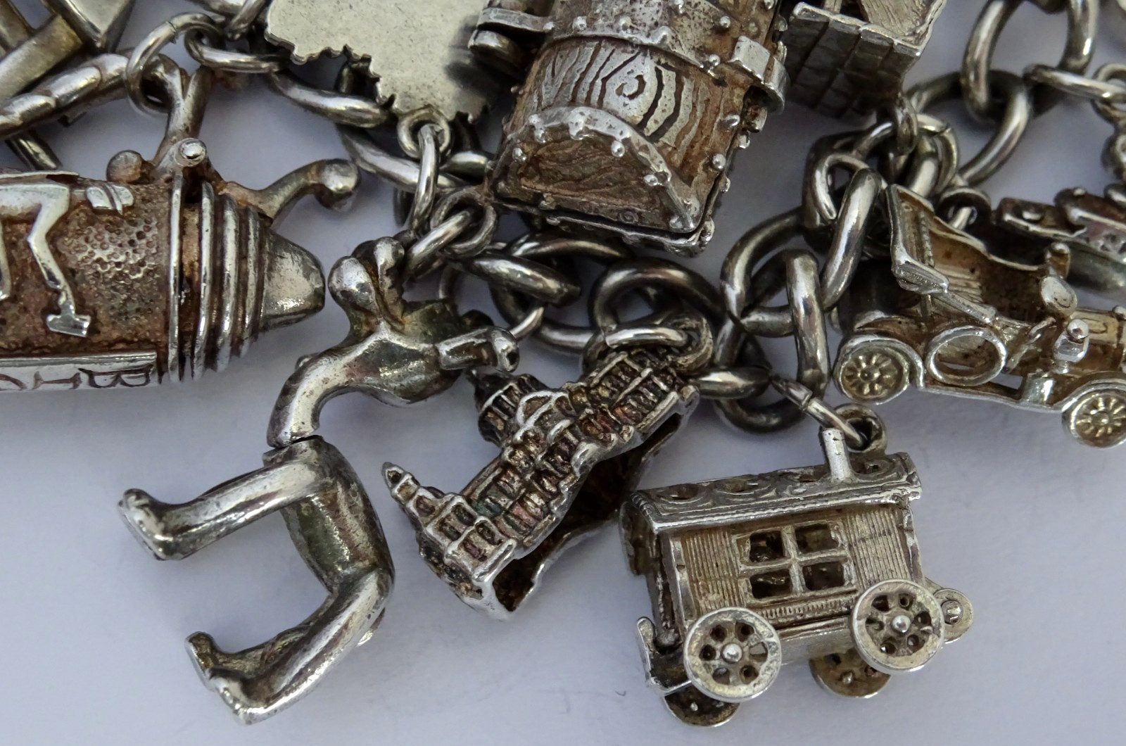 Vintage heavy solid silver charm bracelet &many curious silver charms inc moving