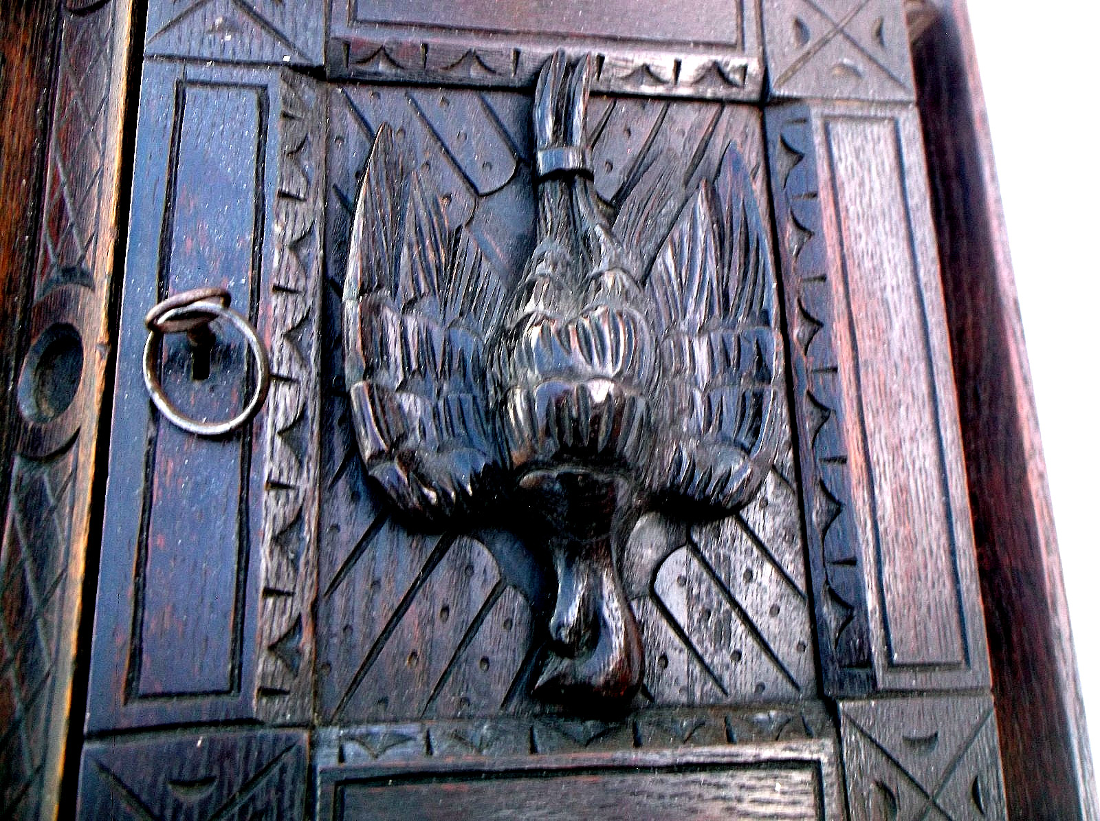 A RARE ANTIQUE OAK CORNER CABINET WITH A CARVED DEAD GAME BIRD ON THE FRONT DOOR