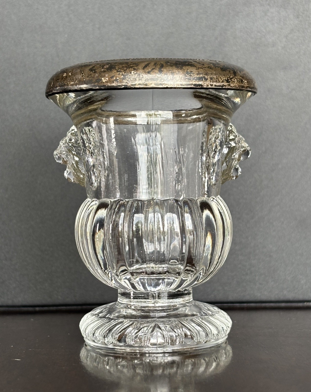 F.B Roger pressed glass toothpick holder with a silver rim and molded lion heads
