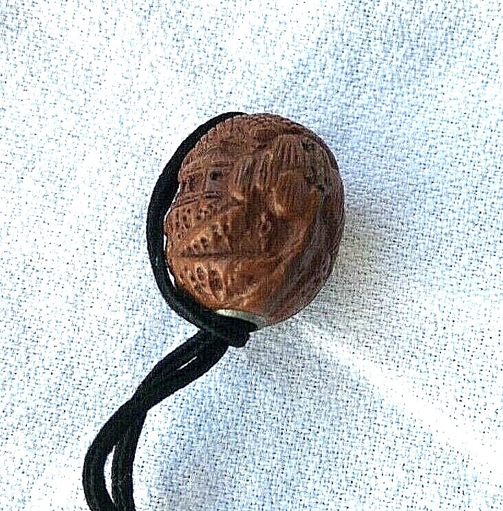 SMALL WOOD NETSUKE WITH INTRICATE CARVINGS ON THE SURFACE