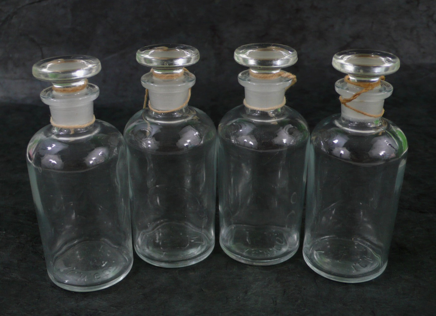 ANTIQUE SET of 4 T.C.W. Co. GLASS APOTHECARY JARS w/GROUND STOPPERS 3.75″ x 1.5″