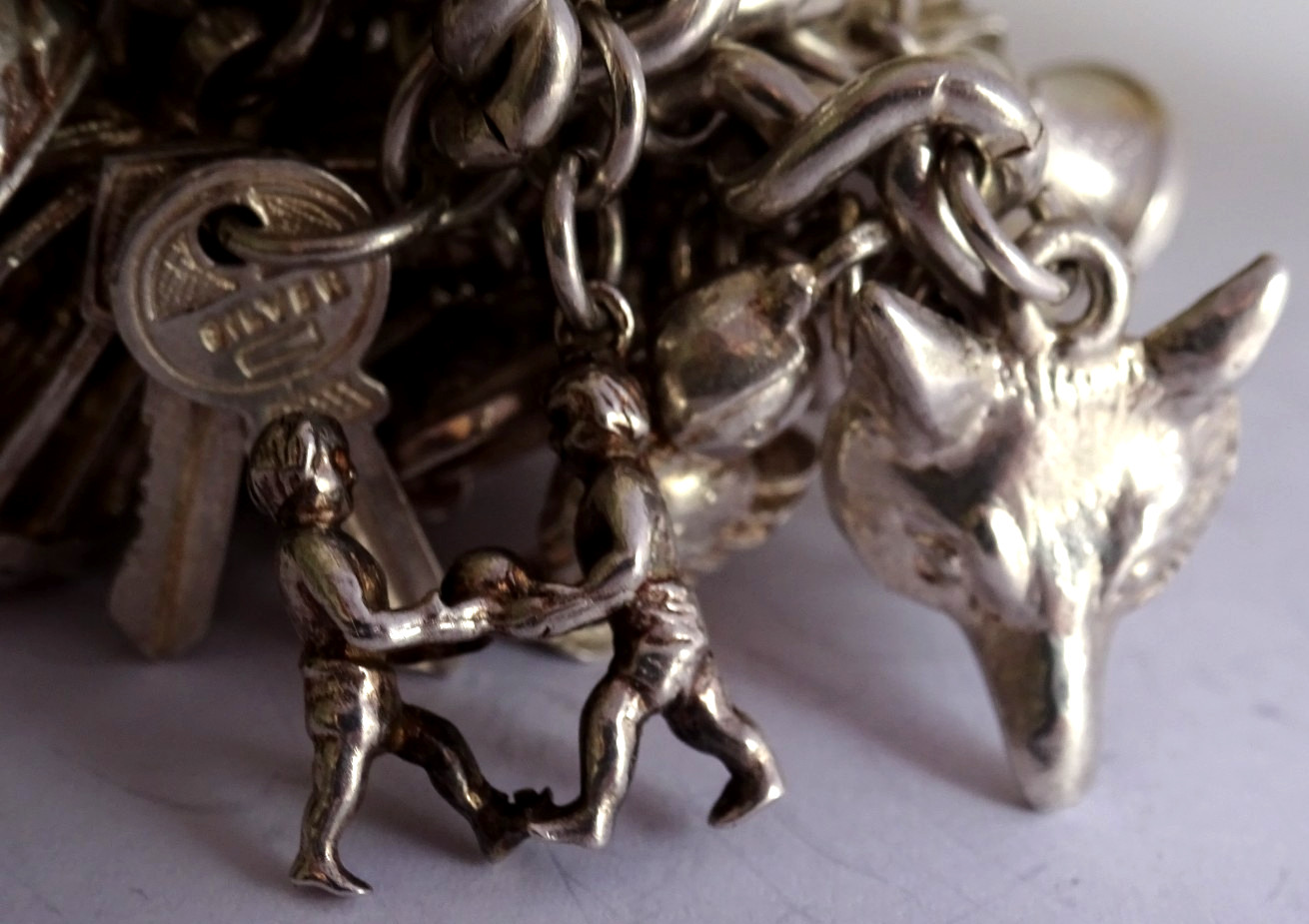 Vintage 102.5g solid silver charm bracelet,many curious silver charms inc moving