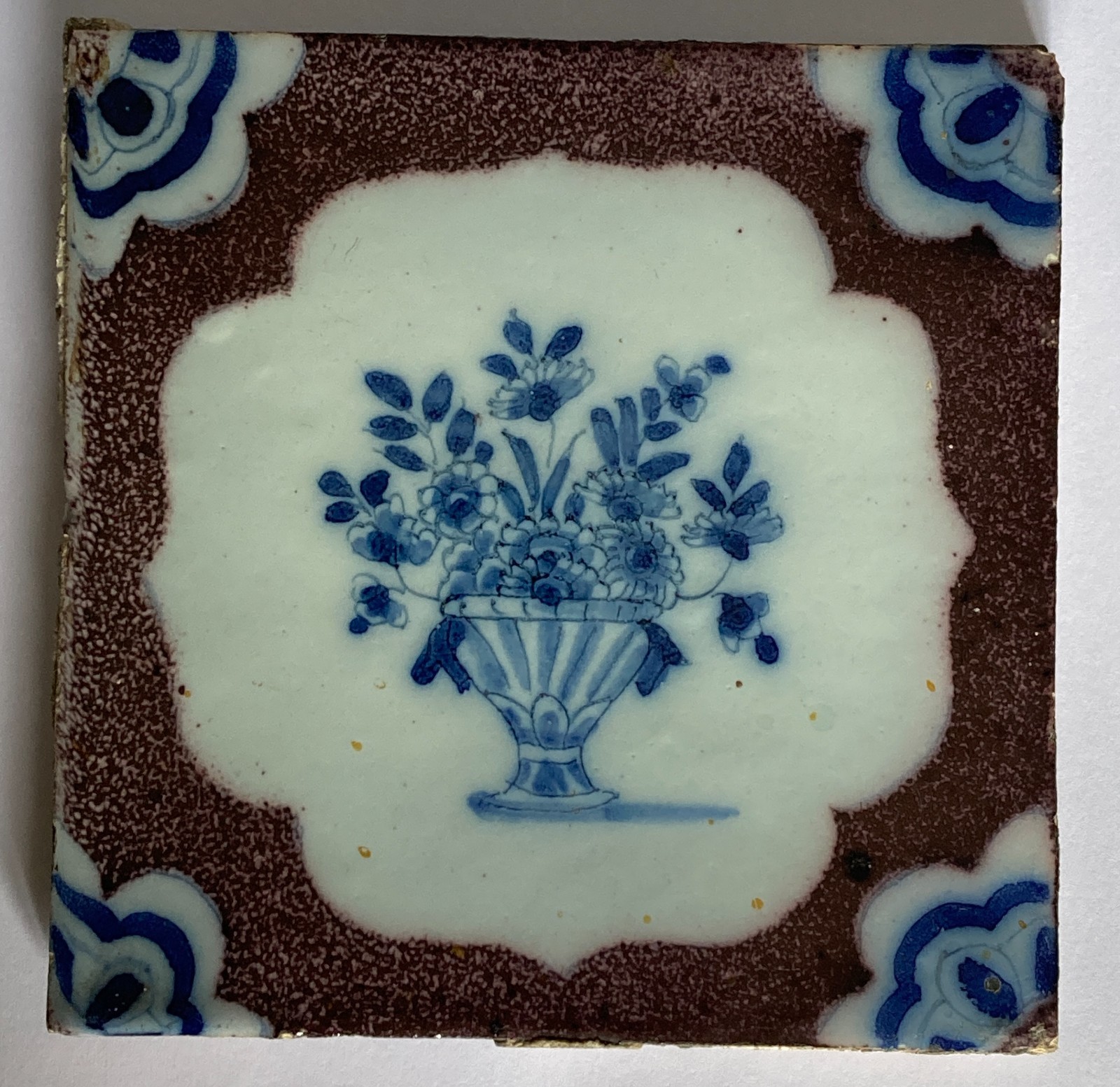 18th century Bristol English Delft manganese tile painted with a vase of flowers