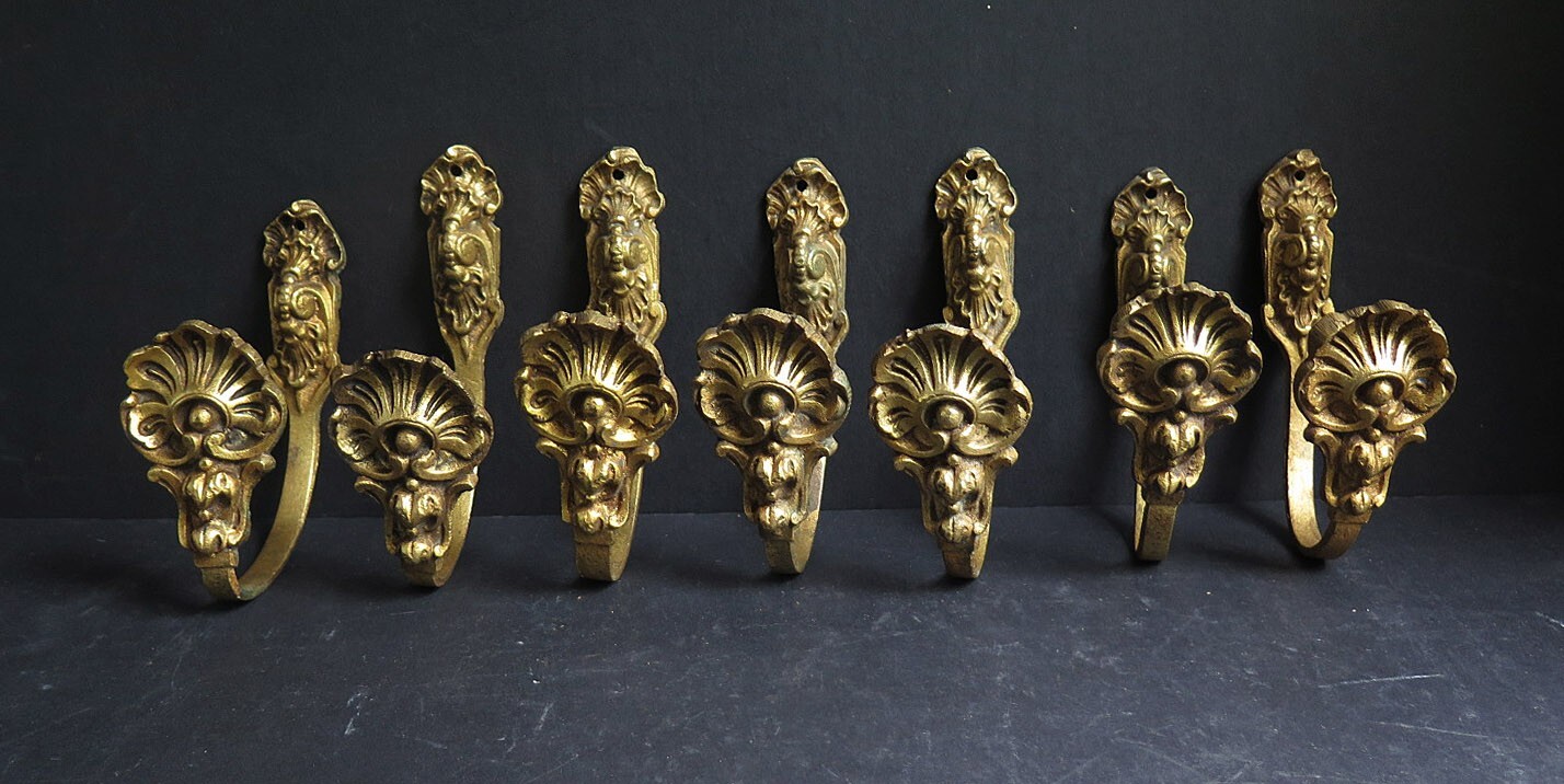 SEVEN SMALL EARLY 20th CENT GILT BRASS FRENCH TIE BACKS WITH SHELL DESIGN