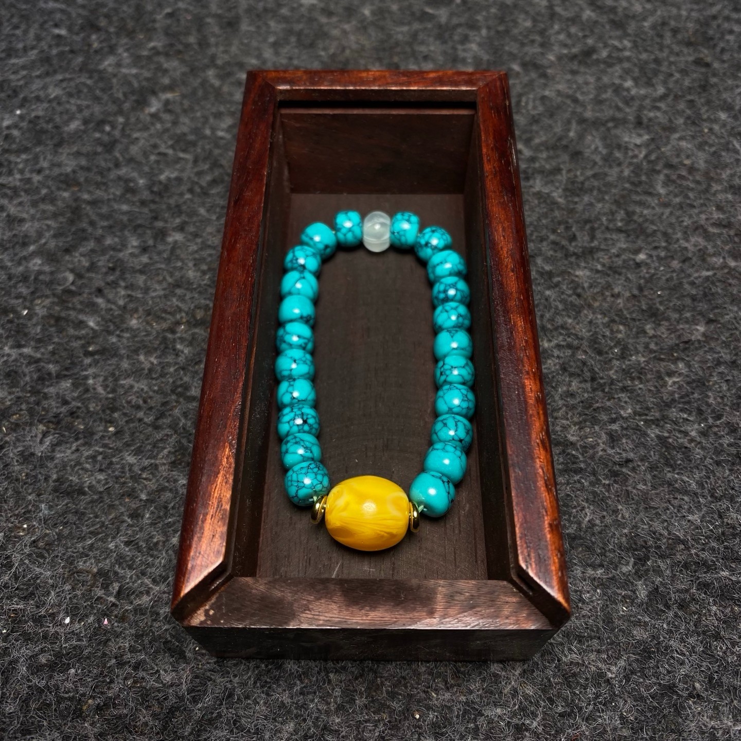 Pinestone bracelets are placed inside a rosewood inlaid with colorful shells box