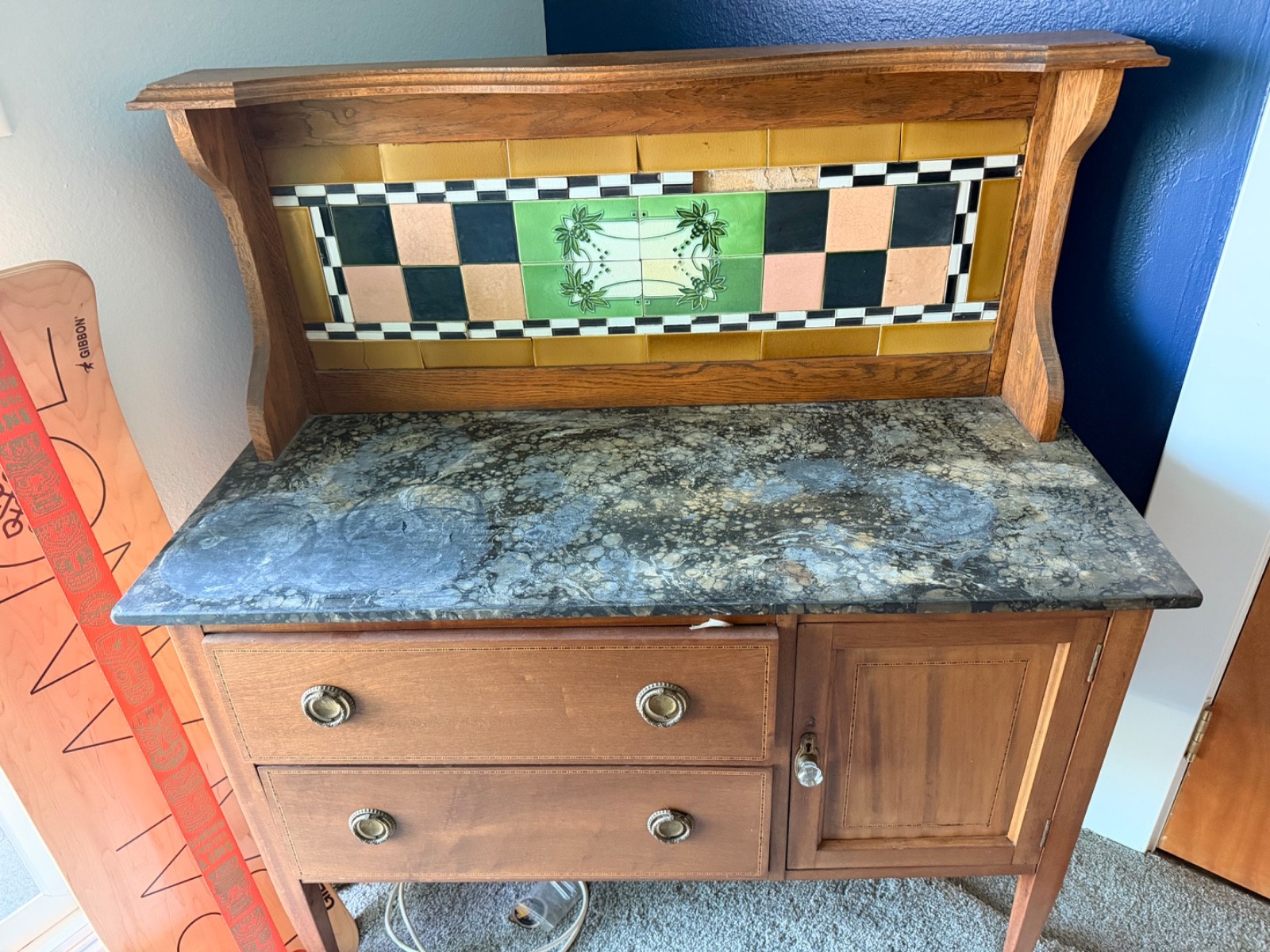 It’s a vintage wooden sideboard/buffet with a decorative tiled backsplash and a