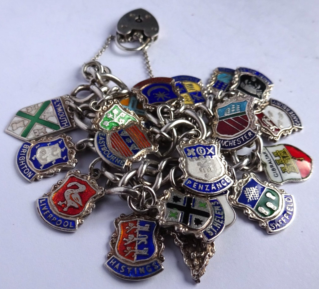 Vintage solid silver charm bracelet & numerous silver & enamel travel shields